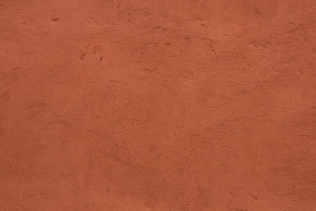 Full frame image of textured stucco in bright terracotta color. High resolution texture of plaster for 3d models, background, pattern, poster, collage, gift wrap, wallpaper etc.