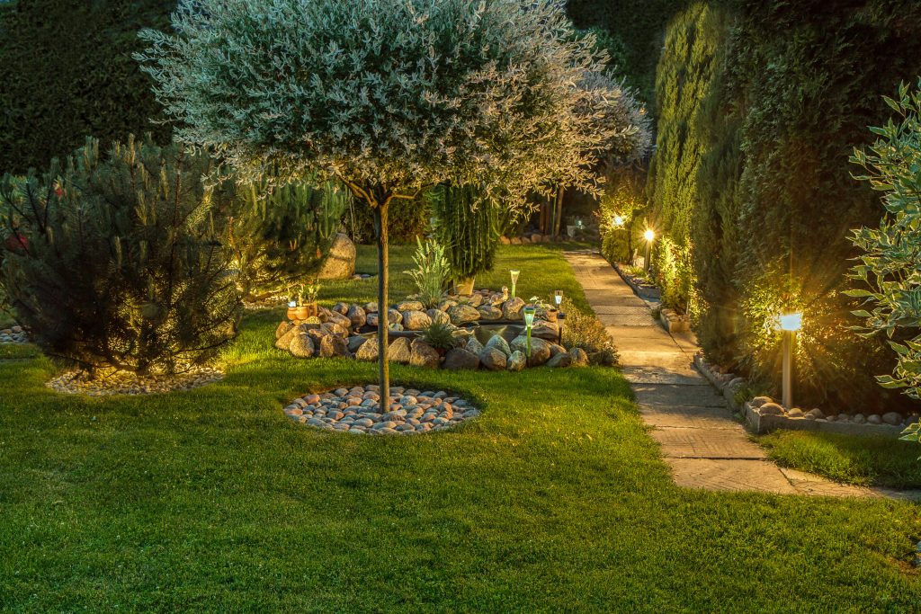 Private garden in the evening, illuminated by lamps