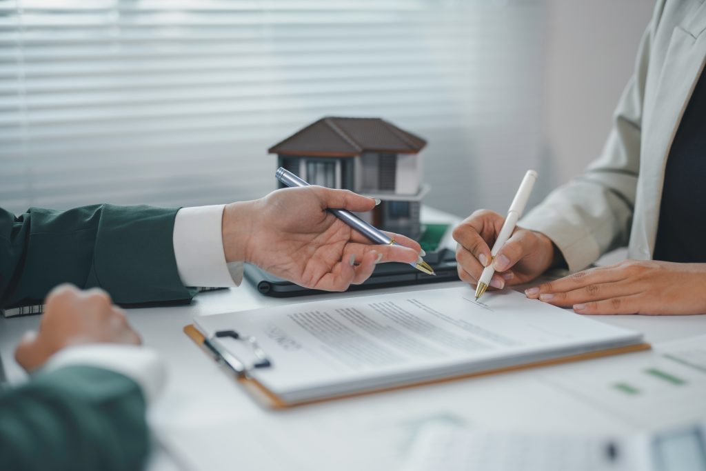 A Practical Guide to Off-Site Construction for Oak-Framed Buildings 5 Client signing a contract for a new house, real estate agent pointing at signature place