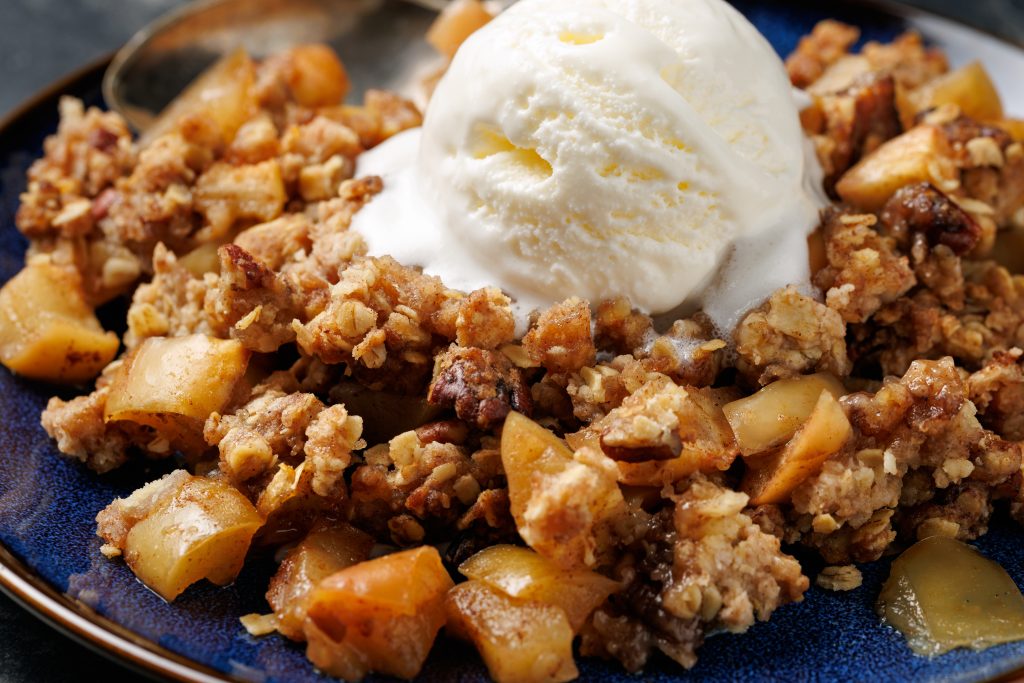 Freshly baked apple crumble pie with ice cream.
